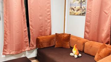 Una sala de estar con un sofá marrón, una mesa de centro negra y una chimenea.