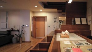 A modern reception area with a wooden reception desk, a seating area with a sofa, and a staircase leading to an upper level.