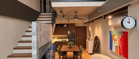 Un interior moderno con una escalera, un comedor y un mueble de asiento original.