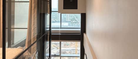 A staircase leading to a balcony with a view of construction outside.