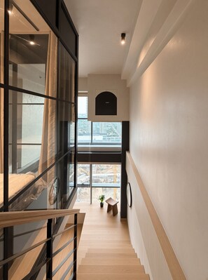 Eine Treppe führt zu einem Balkon mit Blick auf eine Baustelle.