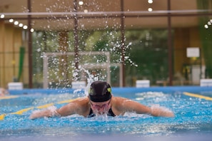 Un nageur dans une piscine, l’eau éclaboussant tout autour.