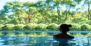 A person in a swimming pool with a view of trees and bushes. - Seimei No Mori Resorts (Chiba)