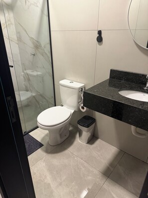 Une salle de bain moderne équipée de toilettes, d’un bidet et d’un lavabo en marbre noir.
