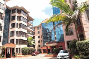 A multi-story residential building with a modern design, featuring balconies and a mix of glass and brick facades. - Gemsuites Luxury Serviced Apartments (Nairobi)