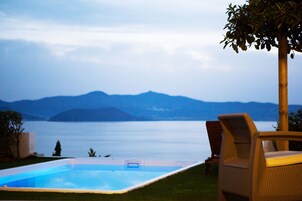 Una piscina con vistas a montañas y una masa de agua.