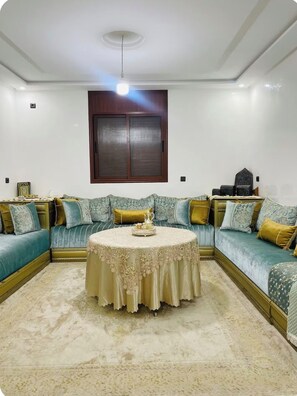 A living room with a round coffee table, sofas, and a wooden cabinet.