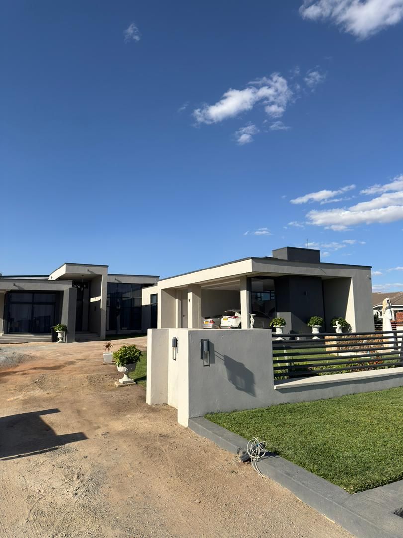 Een modern huis met twee verdiepingen en een overdekte patio.
