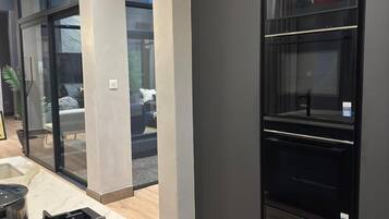 A modern kitchen with a built-in stove, oven, and glass-fronted cabinets.