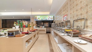 Un aparador de buffet amb diverses estacions de menjar i un panell digital amb el menú.