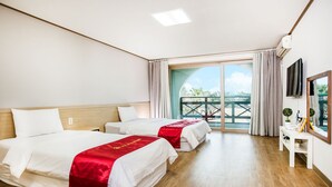Habitació d'hotel amb dos llits, un balcó, una televisió i un escriptori amb mirall.
