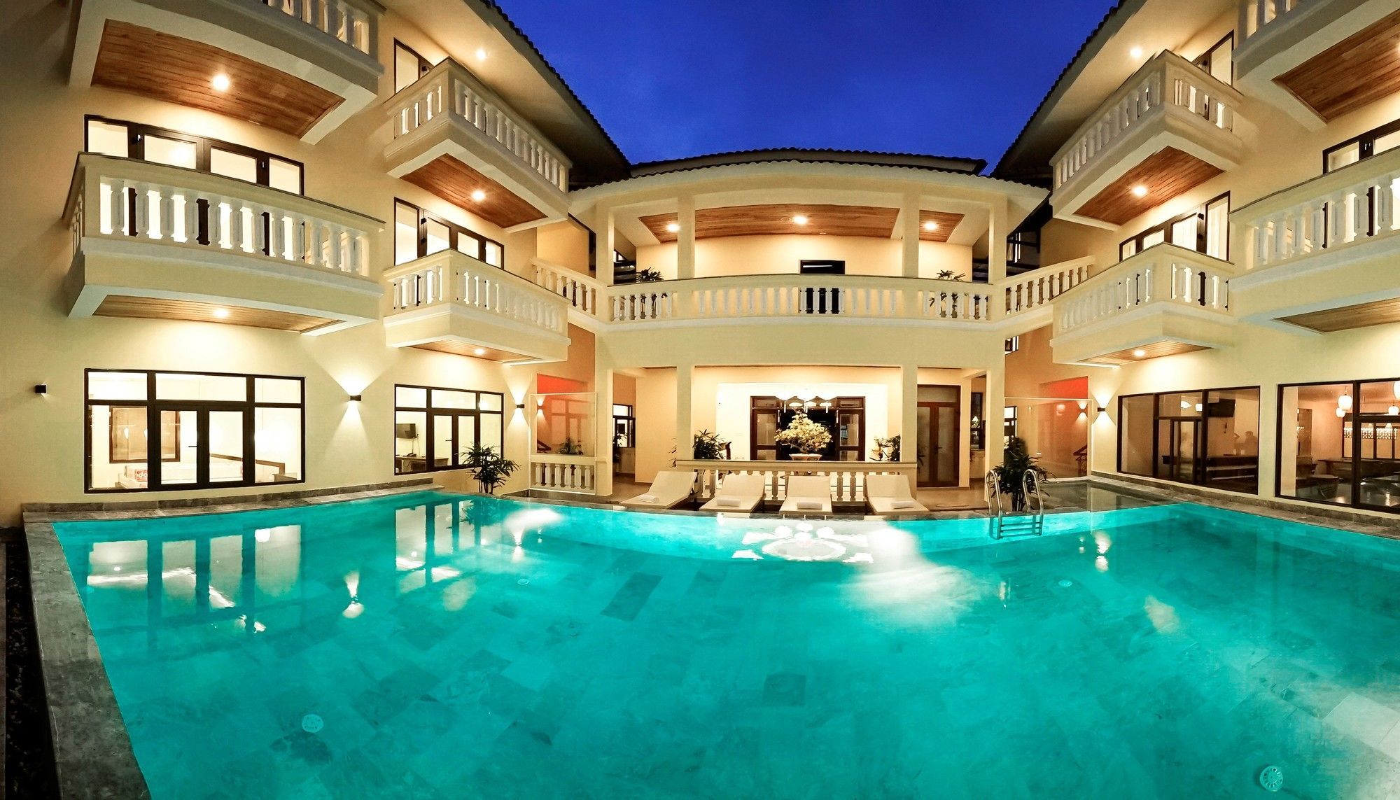 A multi-level pool area with a central seating area and multiple balconies.