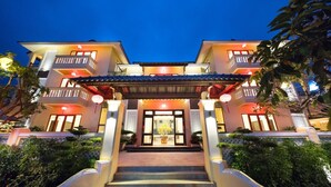 A multi-story hotel with a traditional entrance, steps leading up to the main door, and a covered walkway. - Le Pavillon Villa (Da Nang Municipality)