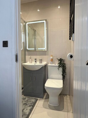 Ein modernes Badezimmer mit Toilette, Waschbecken und Spiegel.
