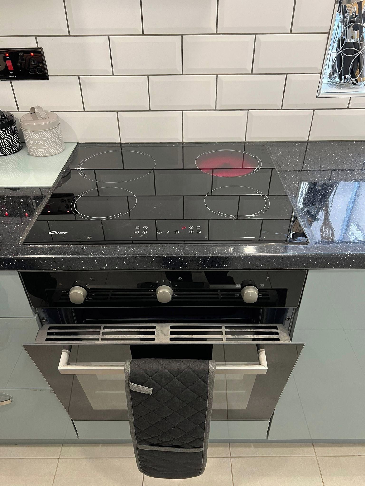 A kitchen with a black stovetop, a silver oven, and a black range hood.