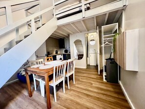 A compact living space with a dining area, kitchen, and a staircase leading to an upper level. - Apartment Sleeps 4 near Station (Purley)