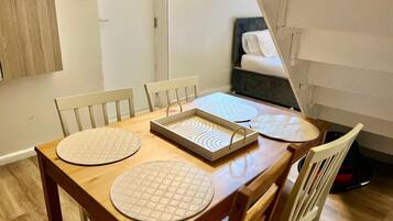 A dining area with a wooden table, four chairs, and a tray with circular placemats.