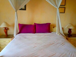 A bed with a canopy, two nightstands, and two lamps. - Yogyakarta Backpacker 1 (Yogyakarta)