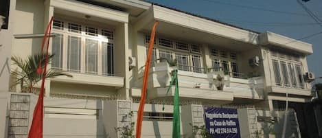 Un edificio de dos pisos con un letrero que anuncia un albergue para mochileros.