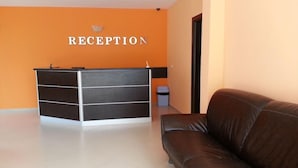Un área de recepción con un escritorio y un sofá.