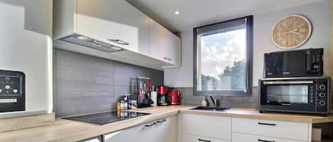 A modern kitchen with a built-in microwave, a coffee maker, and a large window.