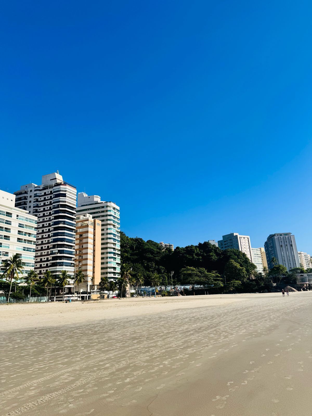 Een strand met hoge gebouwen op de achtergrond.