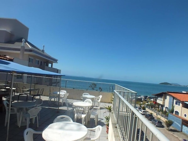 A terrace with outdoor seating and a view of the sea. - Residencial Pousada Do Mar Azul (Florianópolis)