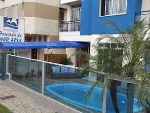 A residential building with a swimming pool, a blue awning, and a sign indicating it is a residential property. - Residencial Pousada Do Mar Azul (Florianópolis)
