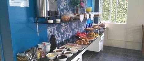 Montaje de bufé con diversos alimentos y una máquina de café.