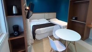 A compact hotel room with a bed, bedside table, and a small dining area with chairs. - Residencial Pousada Do Mar Azul (Florianópolis)