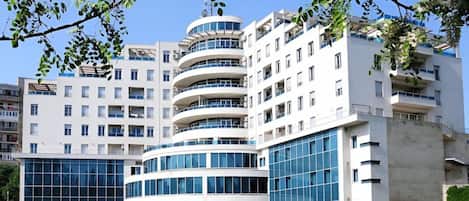 A multi-story building with a modern architectural design, featuring balconies and large windows.
