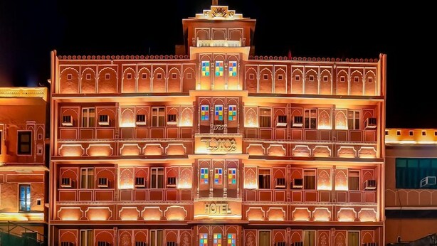 A multi-story building with a traditional architectural style, featuring balconies and arched windows. - L M B Hotel (Jaipur)