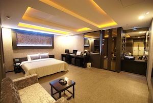 Habitación de hotel moderna con cama, escritorio y zona de estar.