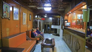 A lobby with a reception desk, seating area, and a glass display case. - Dib Anbessa Hotel (Bahir Dar)