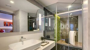 A modern bathroom with a large white sink, a glass shower enclosure, and a mirror above the sink. - Attide Boutique Hotel (Bengaluru)