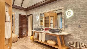 A bathroom with a wooden vanity, a large mirror, and a modern sink.