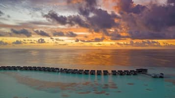 Un resort sobre el agua con varias alojamientos tipo bungalow conectados por senderos.