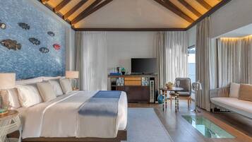A hotel room with a bed, a TV, a desk, and a sofa.