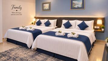Habitación de hotel con dos camas, decoración azul y blanca, una alfombra grande y dos cuadros en la pared.