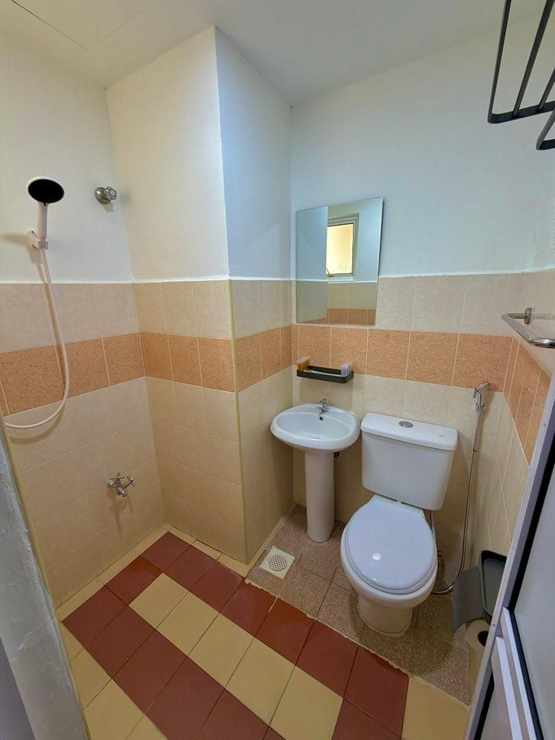 Un baño con ducha, lavamanos e inodoro.