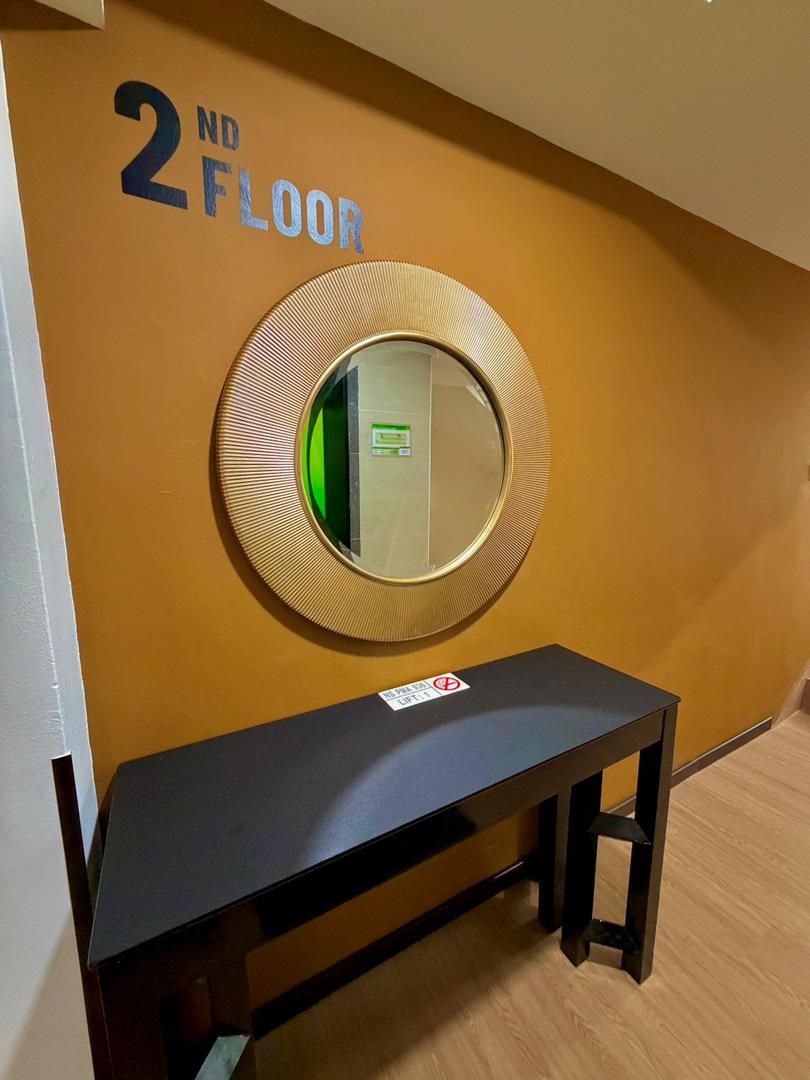 A 2nd floor hallway with a round mirror on the wall, a black bench, and a 'No Smoking' sign.