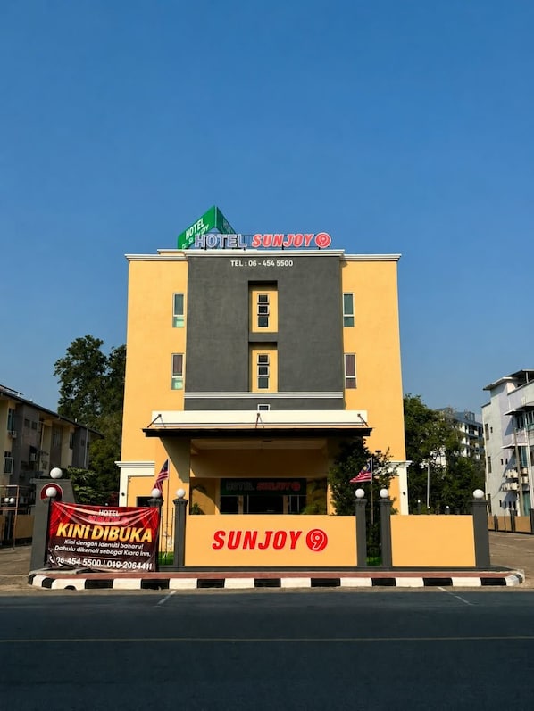 Un hotel llamado 'Sunjoy', con un número de contacto y un cartel que dice 'Kini Dibuka'.