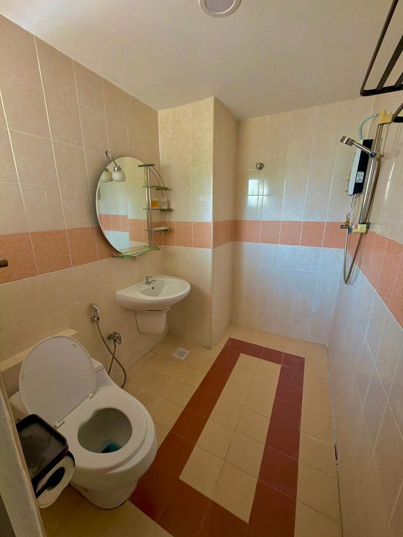 A bathroom with a toilet, sink, and shower.
