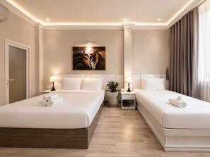 Een hotelkamer met twee bedden, een schilderij aan de muur en een bloempot met plant.