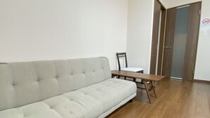 A room with a grey sofa, a wooden table, and a chair. - Kyogura Tofukuji (Kyoto)