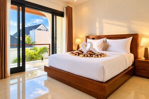 A hotel room with a large bed, a wooden headboard, a nightstand with a lamp, and a view of the outdoors. - Viondra Villas Canggu (Badung)