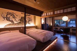 Una habitación tradicional japonesa con dos camas, techo de madera y vista al exterior por una ventana.