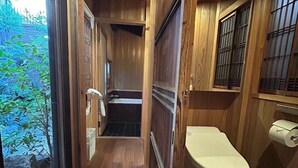 A narrow wooden hallway leading to a bathroom with a toilet and a window. - Shimoza-an (Kyoto)