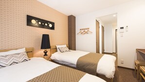 A hotel room with two beds, a wall-mounted lamp, a coat rack, and a door leading to another room. - Hotel Stay Sakura Nipponbashi (Osaka)