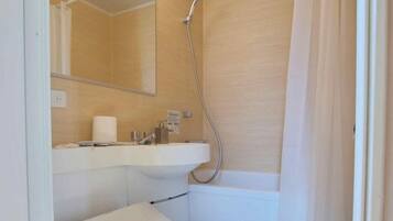 A bathroom with a toilet, sink, and shower.